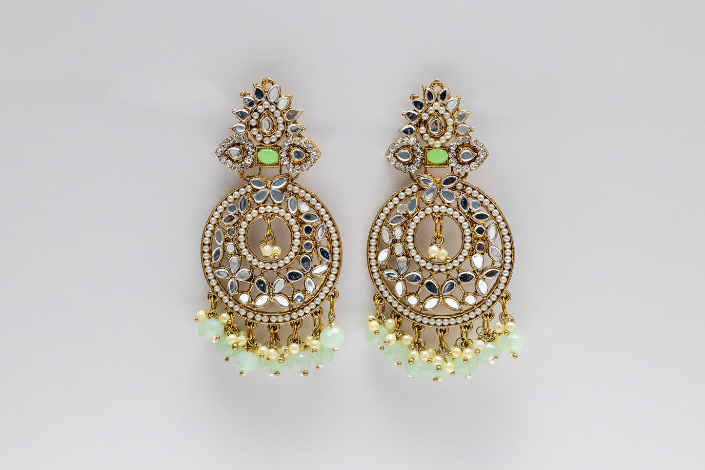 Close-up of Myra Earrings featuring Intricate Kundan Floral Motifs and Pastel Mint Green Drops - Premium Bridal and Festive Accessories. Against a white background