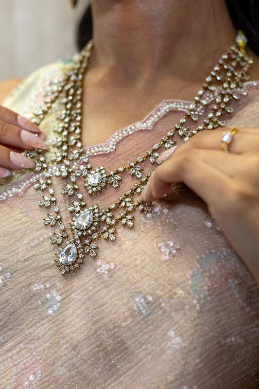 Close-up of Rani Crystal Floral motifs against Pink Saree fabric — Sophisticated wedding guest jewellery for festive celebrations.