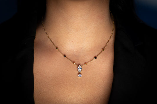 Close-up of a woman wearing the Ekya Mangalsutra, featuring a delicate gold chain with spaced black beads and a sparkling teardrop and round stone pendant.