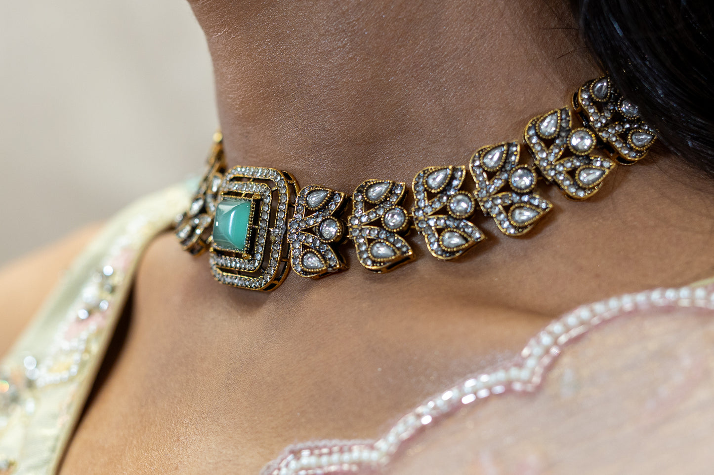Detailed view of Veera Set featuring square-cut Sage Green stones and intricate crystal-encrusted antique gold floral motifs - Premium Modern Heirloom.