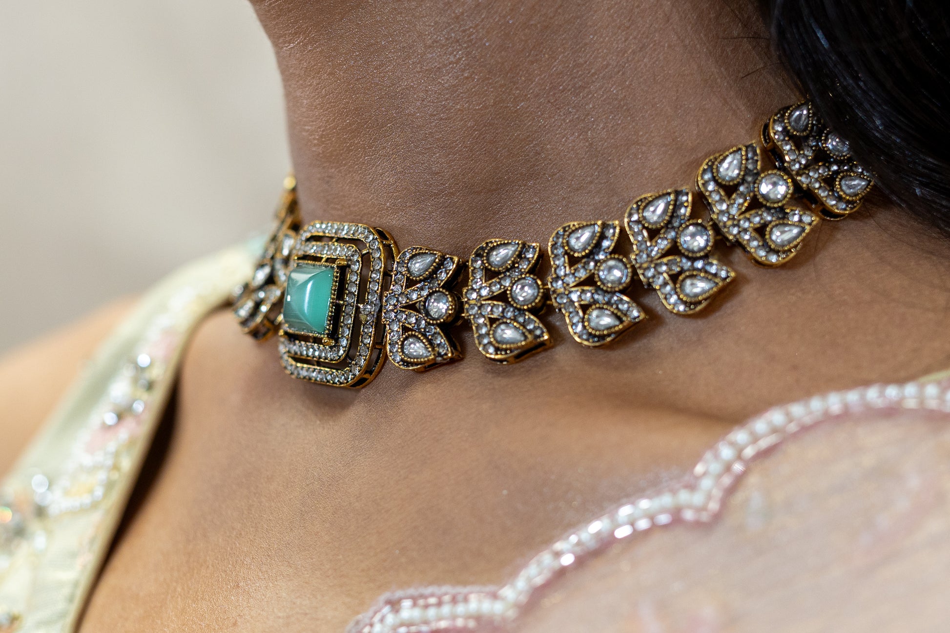 Detailed view of Veera Set featuring square-cut Sage Green stones and intricate crystal-encrusted antique gold floral motifs - Premium Modern Heirloom.