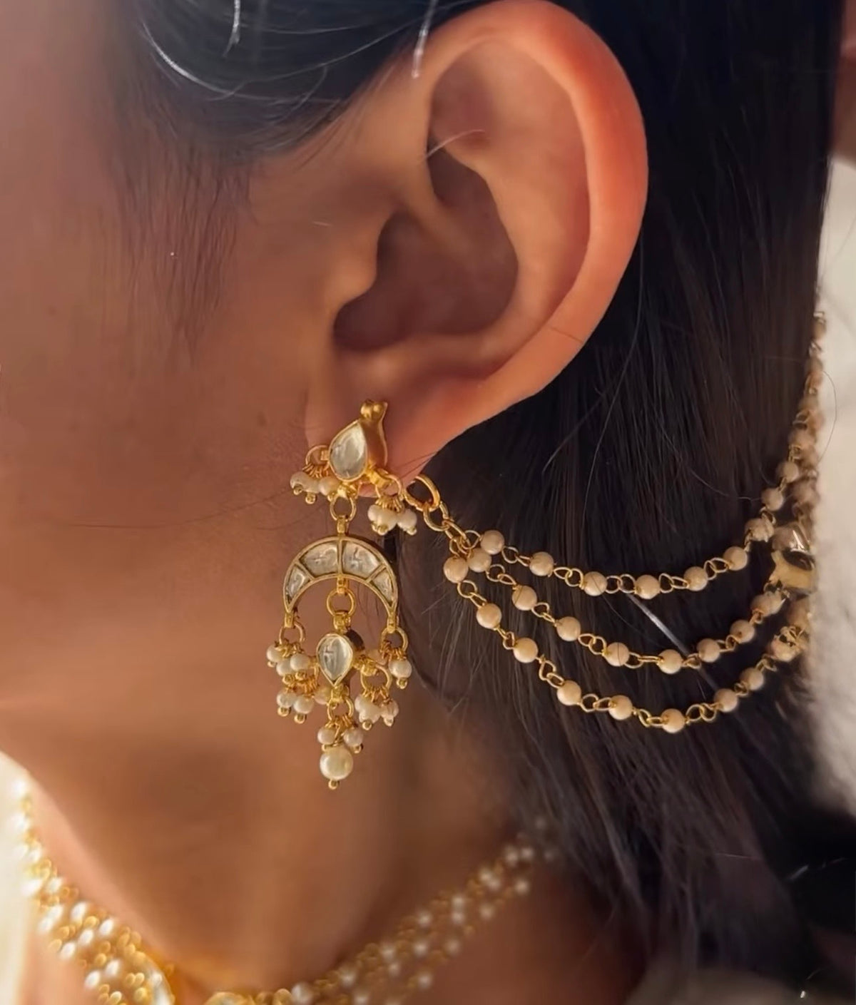 Model wearing the Liyana Set by Kirosa London, featuring a triple-strand pearl Kundan choker and matching chaandbali earrings with pearl sahare ear chains.