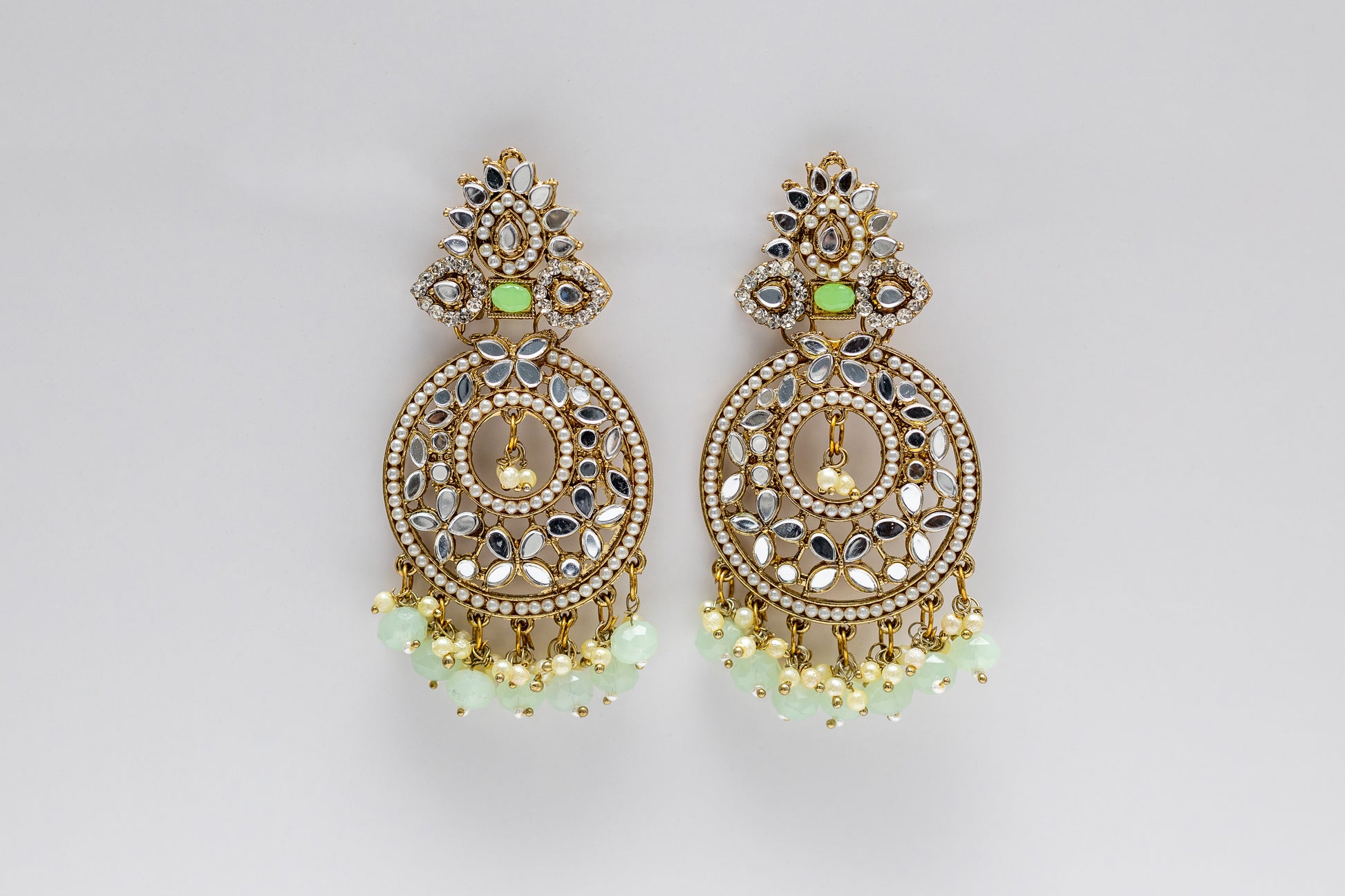 Close-up of Myra Earrings featuring Intricate Kundan Floral Motifs and Pastel Mint Green Drops - Premium Bridal and Festive Accessories. Against a white background