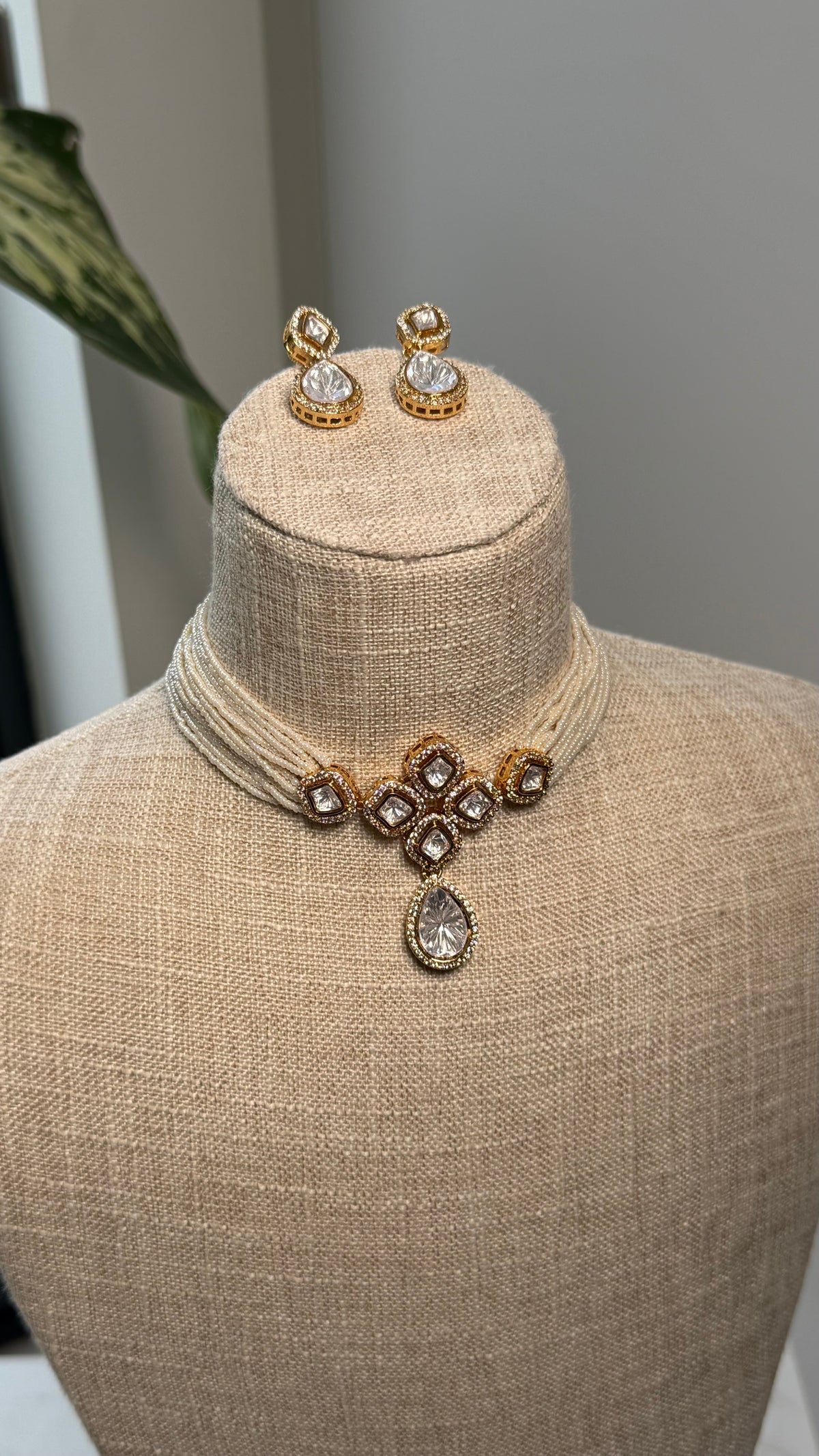 The Nara Set by Kirosa London featuring a multi-strand cream seed bead choker necklace with a gold pave-set Kundan centerpiece, teardrop pendant, and matching drop earrings.