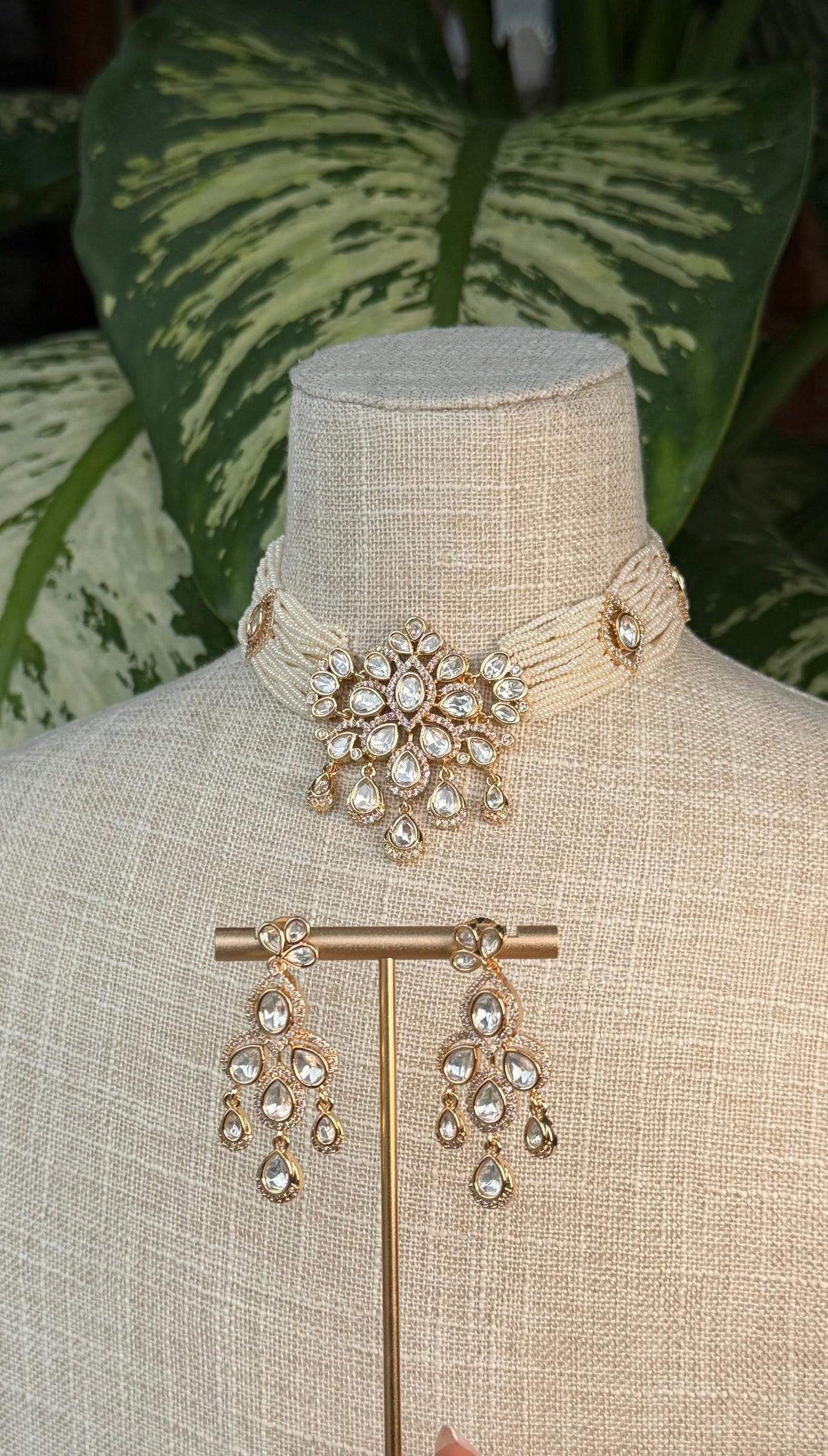 The Saanvi Kundan Set by Kirosa London featuring an intricate multi-strand seed bead choker with a pave-detailed Kundan medallion and matching chandelier drop earrings.
