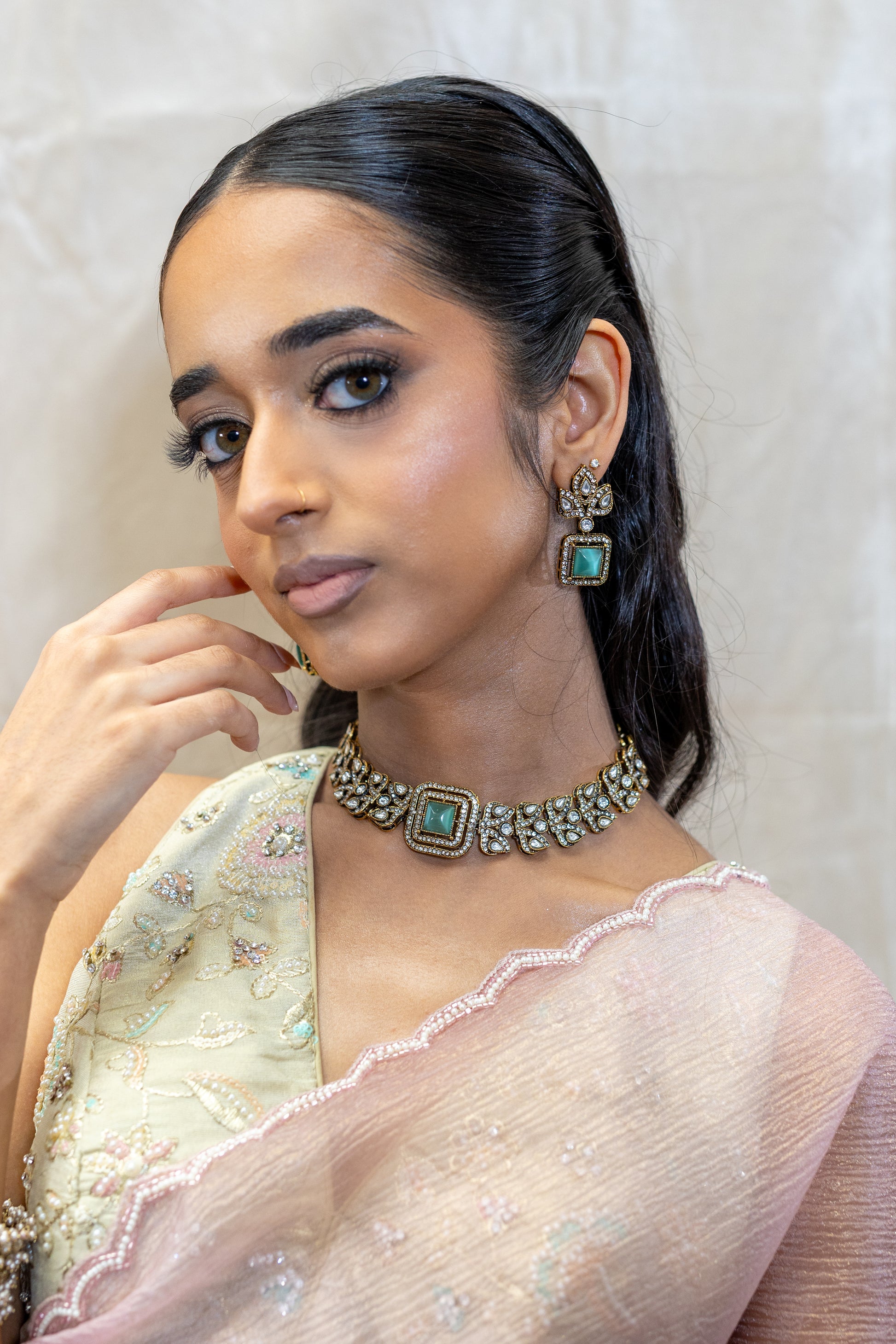 Detailed view of Veera Set featuring square-cut Sage Green stones and intricate crystal-encrusted antique gold floral motifs - Premium Modern Heirloom.